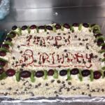 Birthday cake decorated with fruits, chocolates and grapes